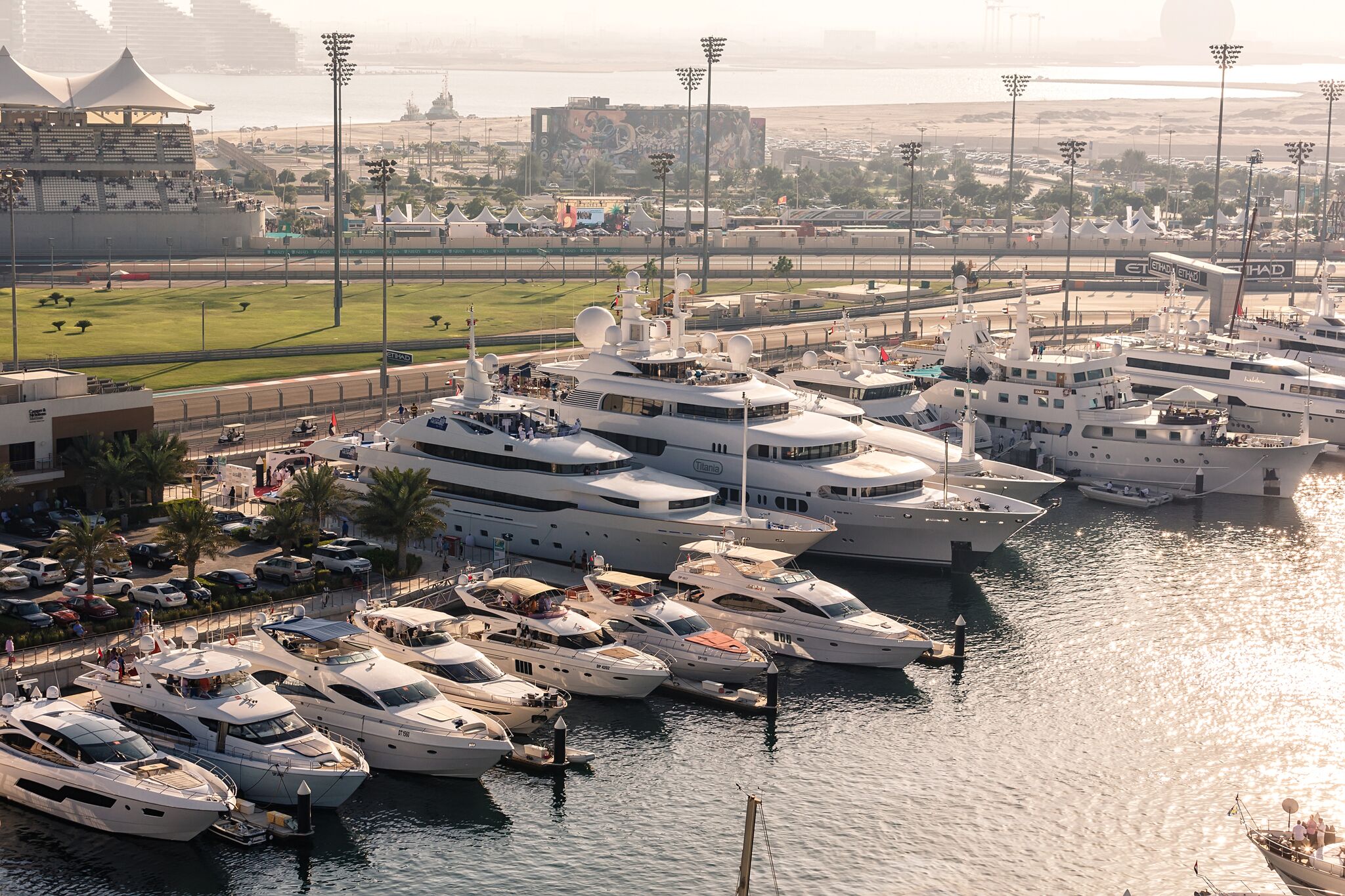 Aerial view of luxury superyachts at Yas Marina with F1 circuit in background